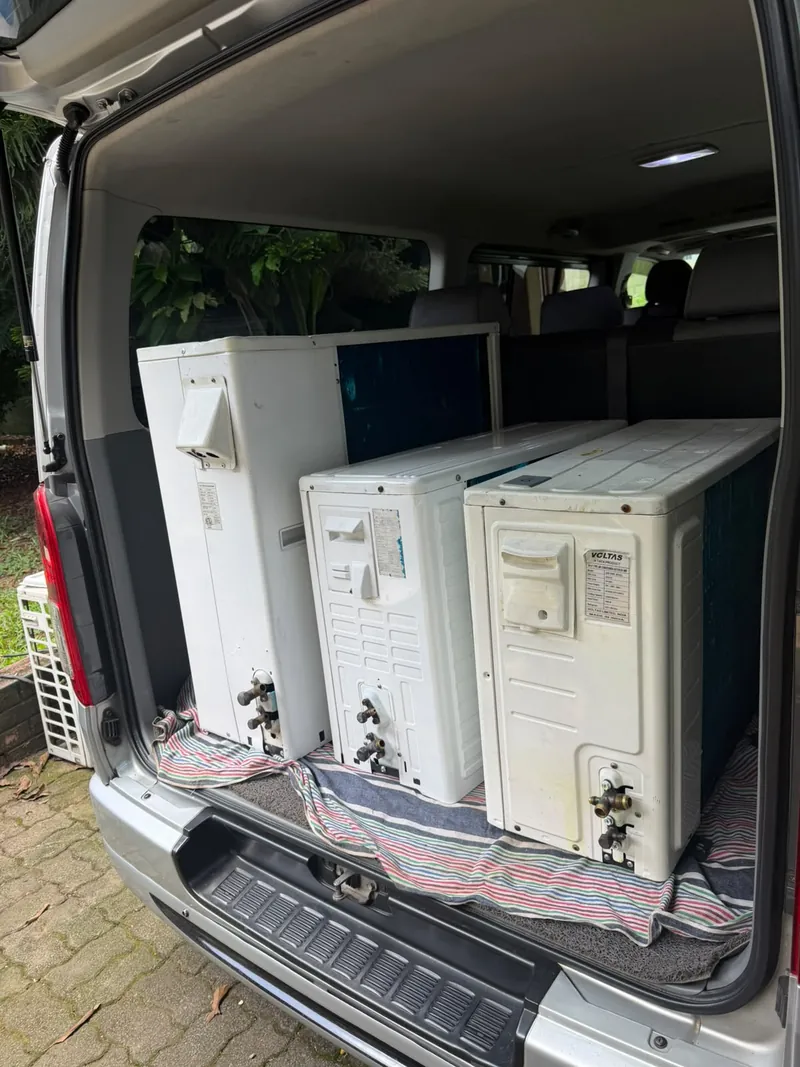 Three outdoor AC units loaded in the back of the Orient team's van