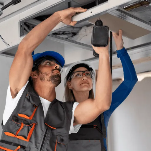 Two technicians fitting a ceiling air conditioning unit